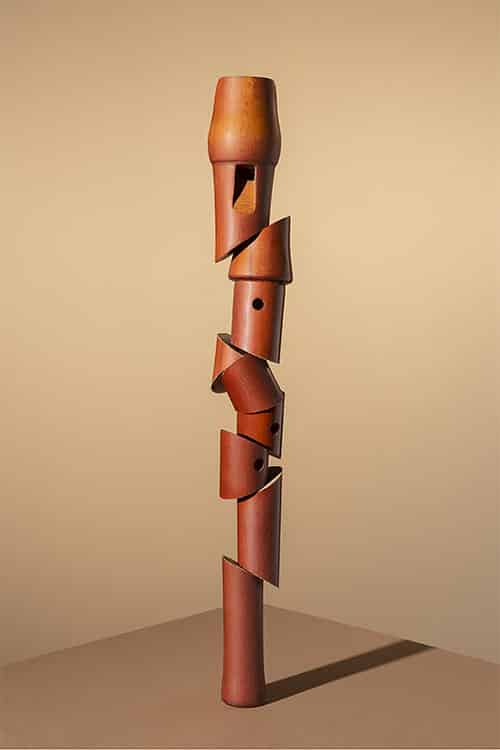 Roodbruine blokfluit verticaal in stukjes aan elkaar geregen als sculptuur |Hans vanAsch