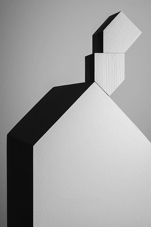 hard belicht huisje met zwarte schaduwen en een schoorsteen gemaakt van kleine huisjes © Hans van Asch